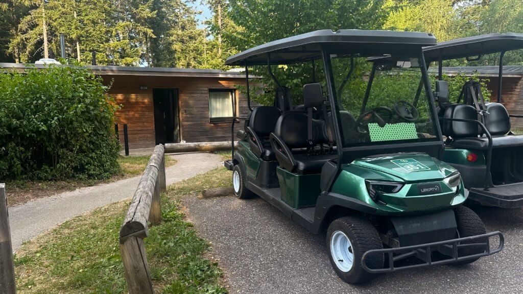 Golfwagen vor einem Ferienhaus im Center Parcs „Les Trois Forêts“